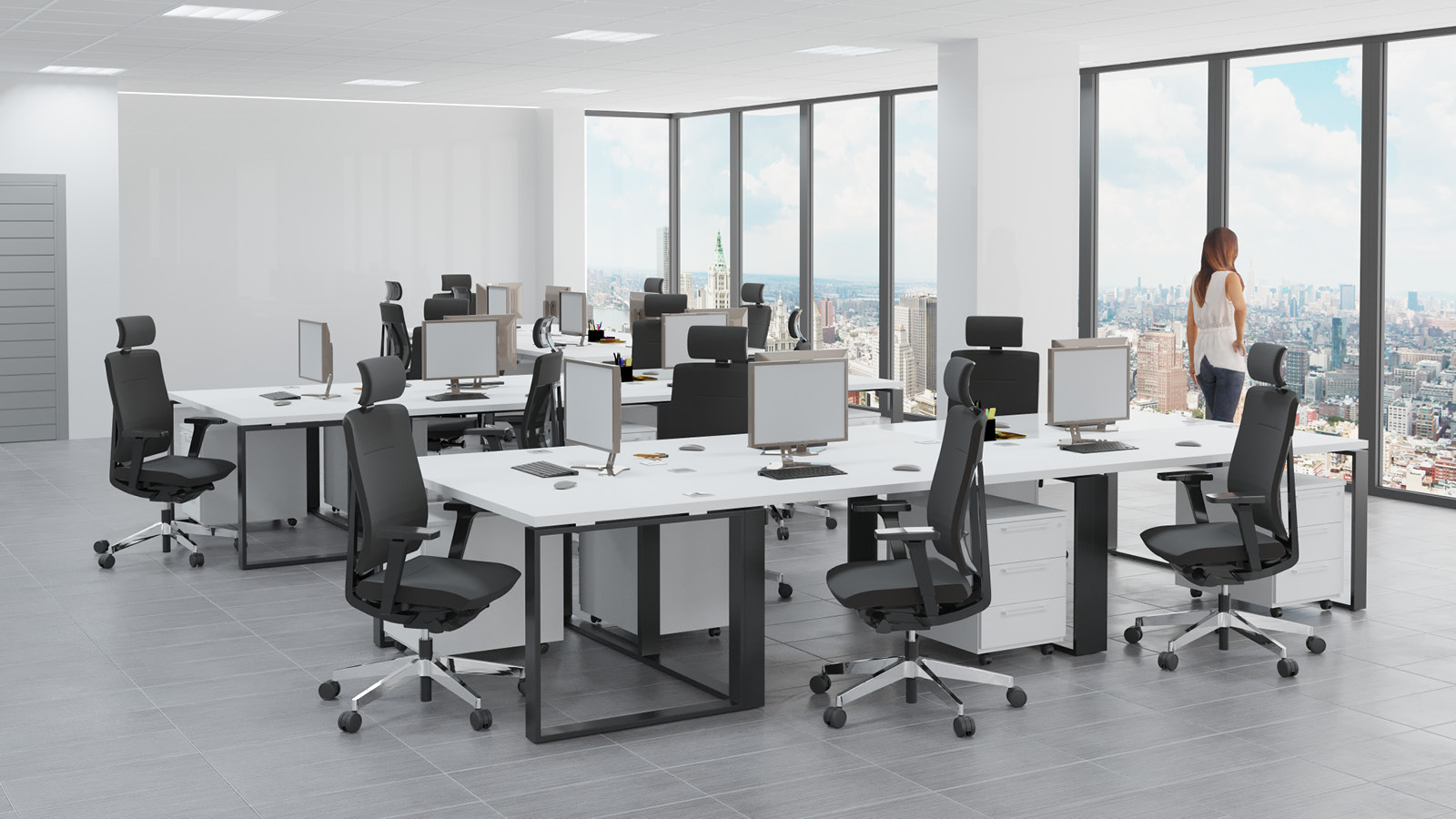 Nowoczesne biuro zostało wyposażone w zestaw do pracy zespołowej - duże biało-czarne biurka z komodami i obrotowymi fotelami.